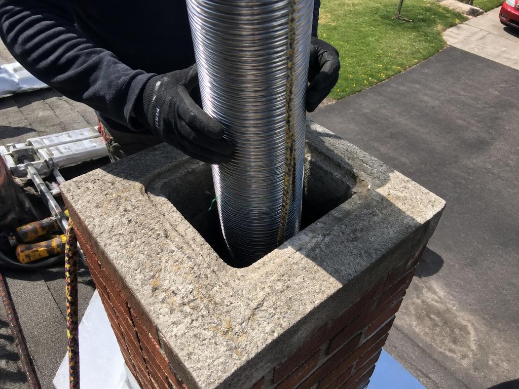 Chimney liner installation on a rooftop in San Antonio, Texas